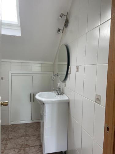 ein weißes Badezimmer mit Waschbecken und Spiegel in der Unterkunft Casa Viña in Valdivia