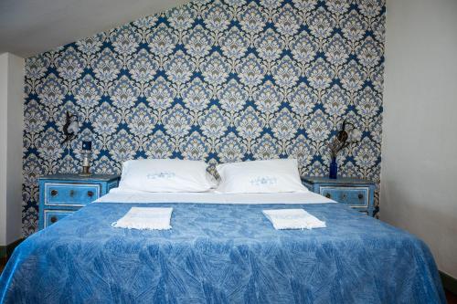 ein blaues Bett mit zwei weißen Kissen darüber in der Unterkunft Casa Palmira in Polcanto