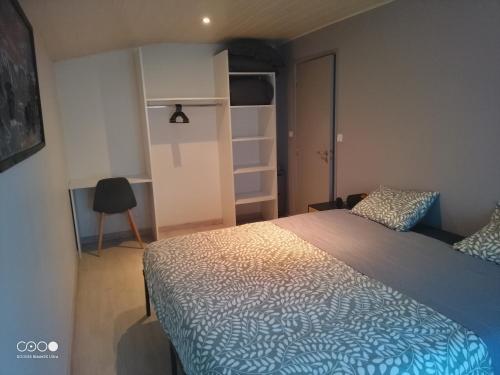 een slaapkamer met een bed en een stoel erin bij Castorette, au calme, petit déjeuner compris in Mimizan