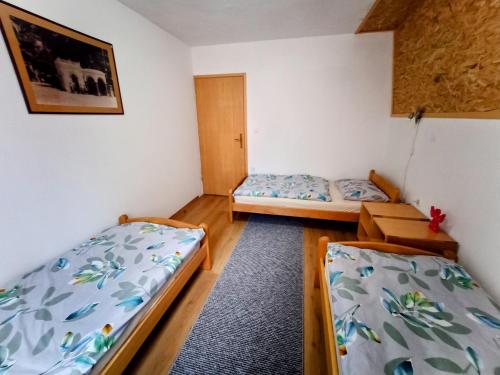 a room with two beds and a table in it at Vikendica Luna in Gornja Šišava