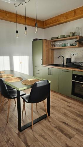 a kitchen with a table and chairs in a room at Apartament NA PIĘTERKU in Rzepiska