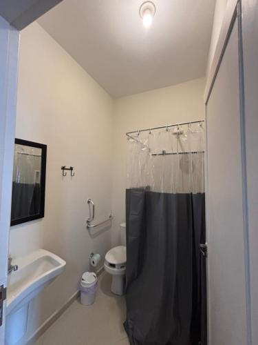 a bathroom with a shower and a toilet and a sink at Mini Studio Villaggio juquehy in São Sebastião