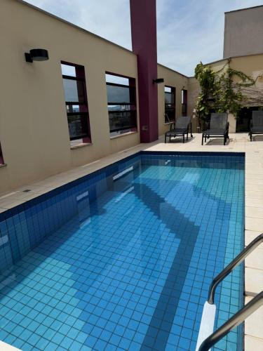 a swimming pool with blue tiles in a building at Hotel Germânia in Joinville