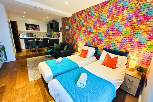 a bedroom with two beds and a colorful wall at Rainbow Studio By My Getaways in Brighton & Hove