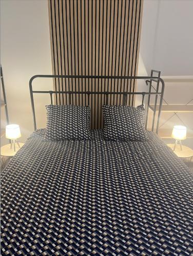 Opal Coast Getaway في Rinxent: سرير بلوح رأس معدني ومصباحين