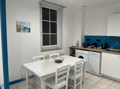 Opal Coast Getaway في Rinxent: مطبخ أبيض اللون مع طاولة وكراسي بيضاء