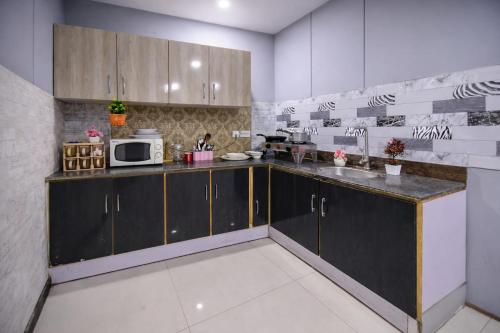 a kitchen with a sink and a microwave at Private 2BD Apartment Opposite Dha Phase 8 in Lahore