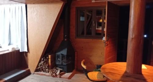 a room with a fireplace and a table in a room at Refúgio Bocaina in Bocaina do Sul