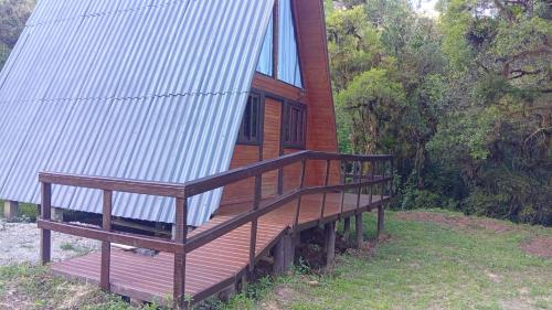 a house with a deck with a roof at Refúgio Bocaina in Bocaina do Sul