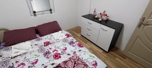 een kleine slaapkamer met een bed en een dressoir bij DIMI Aparmants in Kruševo