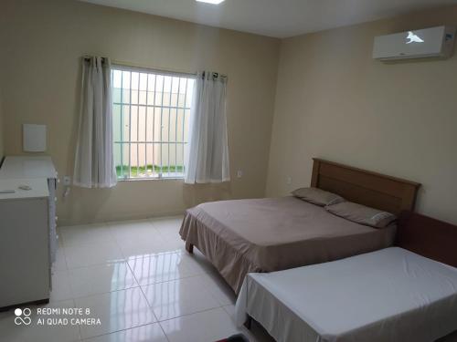 una camera da letto con due letti e una finestra di CASA 400 m DA PRAIA 3 QUARTOS GURIRI NORTE a São Mateus