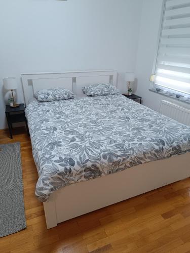 a bedroom with a bed with a gray comforter at Studio apartman - Sweet&Little in Vrbovec