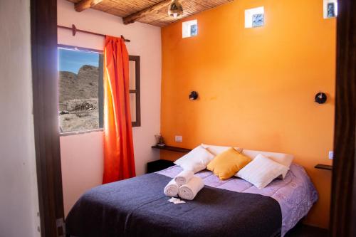 - une chambre avec un lit doté de deux tongs dans l'établissement Cabaña Paraíso Cachi, à Cachí