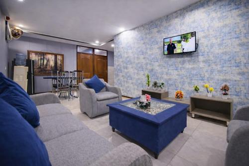 a living room with a couch and a tv on a brick wall at Private 2BD Apartment Opposite Dha Phase 8 in Lahore