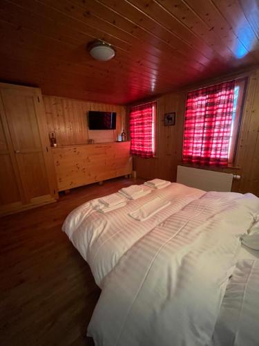 una camera da letto con un grande letto bianco in una cabina di L'Auberge de la Combal a La Comballaz