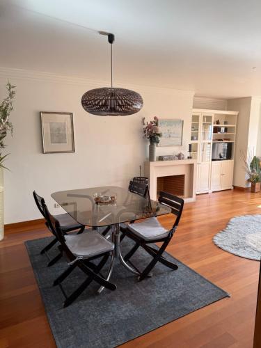 een eetkamer met een glazen tafel en stoelen bij T1 Sea & Pool in Caxias