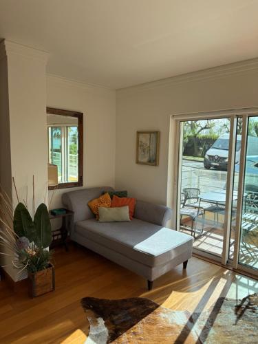 a living room with a couch and a sliding glass door at T1 Sea & Pool in Caxias