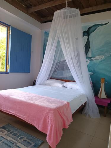 a bedroom with a bed with a mosquito net at Cabin near the beach in El Valle