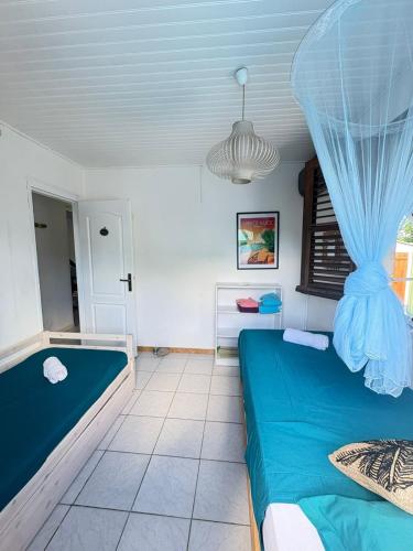 a room with two beds and a ceiling at Villa JOSAMY Charmante Villa avec Piscine à Deux Pas de la Mer in Sainte-Luce