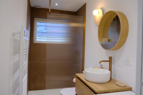 ein Badezimmer mit Waschbecken und Dusche mit Spiegel in der Unterkunft Les vagues - Sea view house in Saint-Martin-Plage