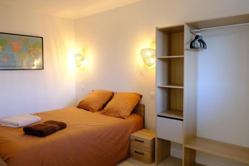 ein Schlafzimmer mit einem Bett und einem Bücherregal in der Unterkunft Les vagues - Sea view house in Saint-Martin-Plage