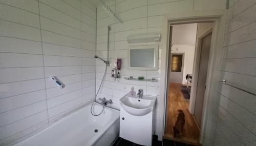een witte badkamer met een wastafel en een bad bij Cozy Cottage 