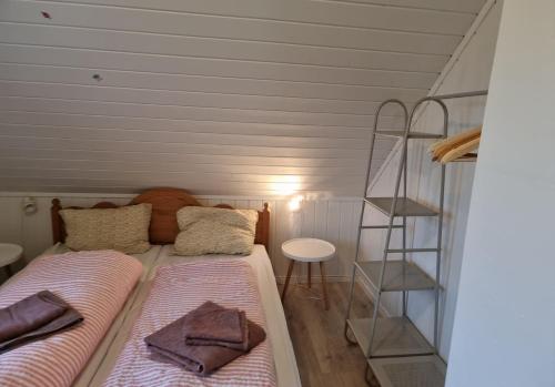 a bedroom with two beds and a book shelf at Cozy Cottage in Balsfjord