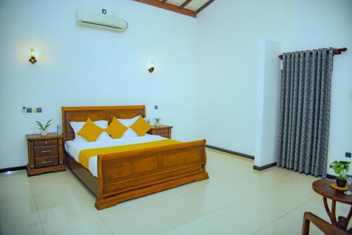 een slaapkamer met een houten bed met gele kussens bij Elevate Villa Galle in Galle