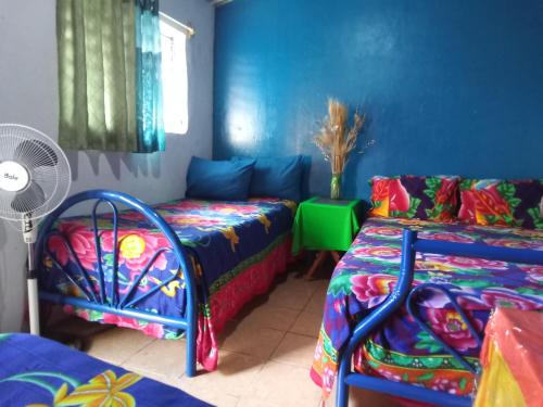 a room with two beds and a fan at El Pacifico in Juayúa