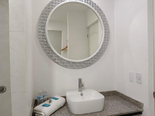 een badkamer met een wastafel en een spiegel bij Zar Guadalajara in Guadalajara