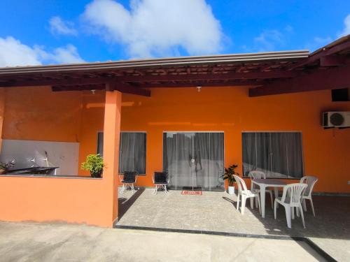 een patio van een huis met een tafel en stoelen bij Casa da Hellen in Porto Seguro