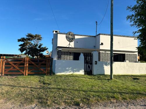 una casa bianca con una recinzione davanti di Alquiler miramar a Miramar