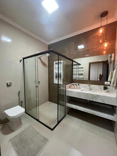 ein Badezimmer mit Dusche, Toilette und Waschbecken in der Unterkunft Flow Pousada in Maringá