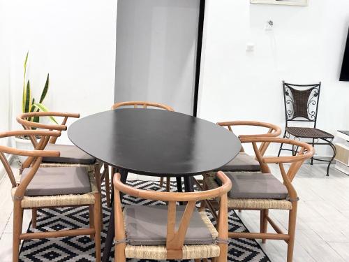 czarny stół jadalny z czterema krzesłami w obiekcie Residences Riverside Abidjan w mieście Abidżan