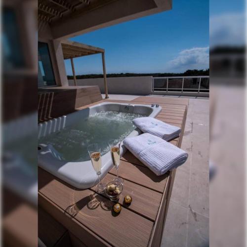 ein Whirlpool auf einer Terrasse mit einem Glas Champagner in der Unterkunft Hotel Figueroa Flow Apart in Buenos Aires