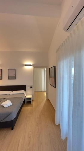 a bedroom with a bed and a white curtain at Mediterranea Apartments Aurora in Assemini
