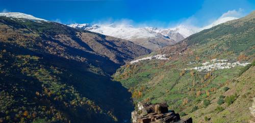een uitzicht op een bergvallei met besneeuwde bergen bij Capileira Luz de Sierra in Capileira