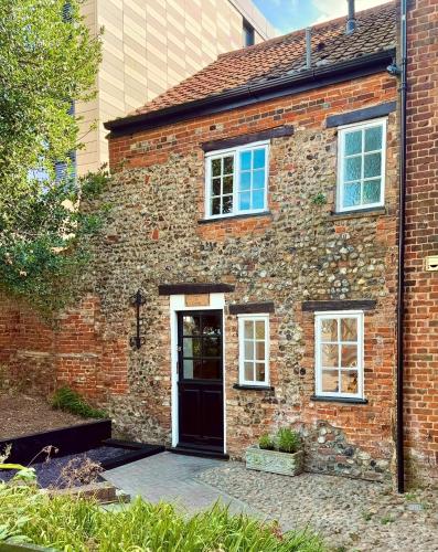 an old brick house with a black door at Foundry Cottage, Duke St Norwich, City Centre in Norwich
