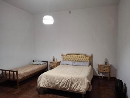 een slaapkamer met twee bedden en twee nachtkastjes bij Lo de Olga in Trelew
