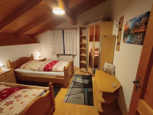 een slaapkamer met 2 bedden, een bureau en een plank bij Ferienwohnung Buchner | Chiemgau Karte in Grassau