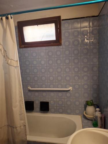 een badkamer met een bad en een douchegordijn bij Lo de Olga in Trelew