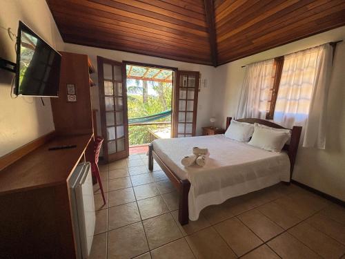 een slaapkamer met een bed met een teddybeer erop bij L´Grace Ferradura in Búzios