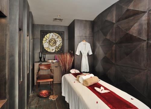 a bedroom with a bed and a table and a dresser at Marina- Shimla First Designer Boutique Hotel in Shimla