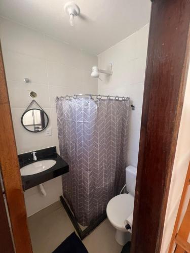 ein Badezimmer mit Dusche, Waschbecken und Toilette in der Unterkunft Casa de Praia Vila do Peró in Cabo Frio