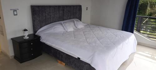 a bedroom with a large bed and a window at Supernova Glamping in Macanal