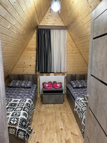 a room with two beds in a wooden cabin at Cottage Godzia in Sadgeri