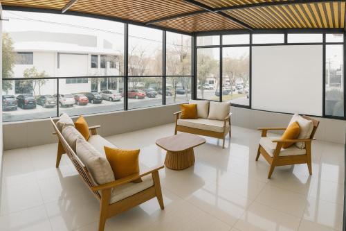 a lobby with chairs and tables and windows at City Tower Hotel in Lima