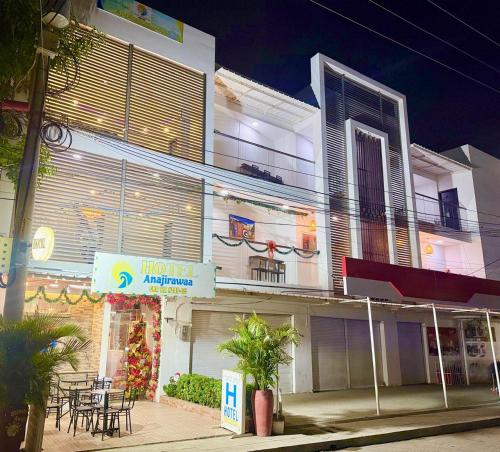 a white building with a restaurant with tables in front of it at ANAJIRAWAA HOTEL in Ríohacha