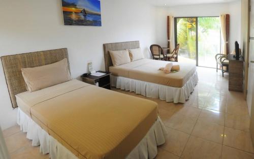 a bedroom with two beds and a table and chairs at Boracay White Coral Hotel in Boracay