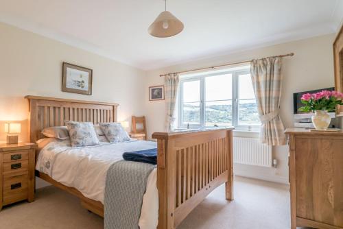 a bedroom with a bed and a window at Llwyn-Y-Coed-Isaf in Llanbedr-y-cennin